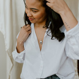 woman wearing button up white blouse and silver oval shaped locket