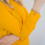 woman wearing gold shirt with gold bangle locket bracelet and silver bangle locket bracelet