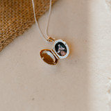 open view of small silver locket with picture inside of man holding child on shoulders