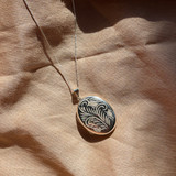 large silver etched evelyn locket that holds two photographs inside