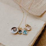 gold chain necklace with mixed metal charms varying photographs placed inside in shape and size