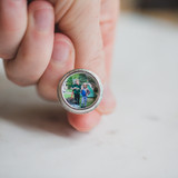 silver cufflinks held in hand to demonstrate size