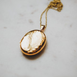 gold oval-shaped locket with etching that holds large photo, double locket