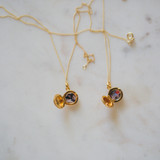 two open photo locket keepsake necklaces on marble