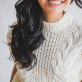 woman with long black hair and white sweater wearing gold edith locket, very small holding pictures inside