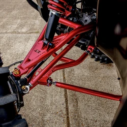 2026 Can-Am Defender HD11, close-up of the red suspension and control arms with black components on the Silver / Red / Black utility vehicle.