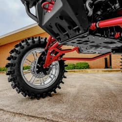 2026 Can-Am Defender HD11, close-up of the silver alloy wheel, rugged off-road tire, red suspension and black underbody skid plate.