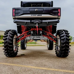 2026 Can-Am Defender HD11, rear view showcasing oversized off-road tires, red suspension components, winch, and silver, red, and black finish