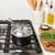 basalt 1.5qt saucepan with lid on stovetop, cutting board with ingredients next to stove on countertop