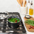 basalt 1.5qt saucepan filled with string beans on stovetop, lid placed behind pan and cutting board with ingredients next to stove on countertop