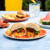 outdoor table scene with plated burger cut in half with melted cheese inside patty
