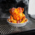 roasted chicken on vertical chicken roaster and veggies on outdoor grill