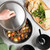 nordic ware 6 qt aluminum dutch oven with stew; hand holding lid by the knob