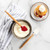 Two small Nordic Ware spatulas with biscuits, berries, and whipped cream on wooden surface