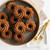 Golden spice cakes baked in Nordic Ware Heritage Bundtlette pan, swirled fluted design, arranged on dark plate