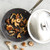Nordic Ware Basalt black 10-inch sauté skillet with lid, containing sautéed golden mushrooms