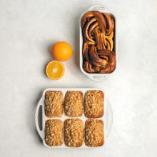 overhead view of cardamom bakeware loaf and mini loaf pans with loaf bread and mini loaf cakes