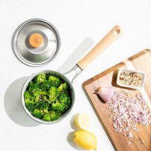 cardamom 1.5qt saucepan on with broccoli, lid next to it with cutting board of ingredients