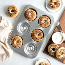 overhead of sourdough bagel pan with bagels in pan and on cutting board
