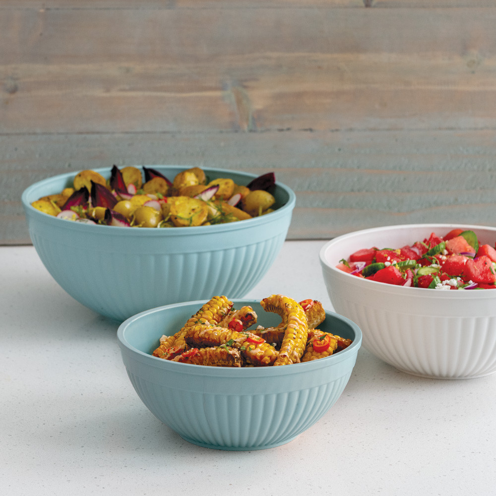 3 piece prep and serve mixing bowl set staged on countertop filled with potatoes, corn cobs, and fruit