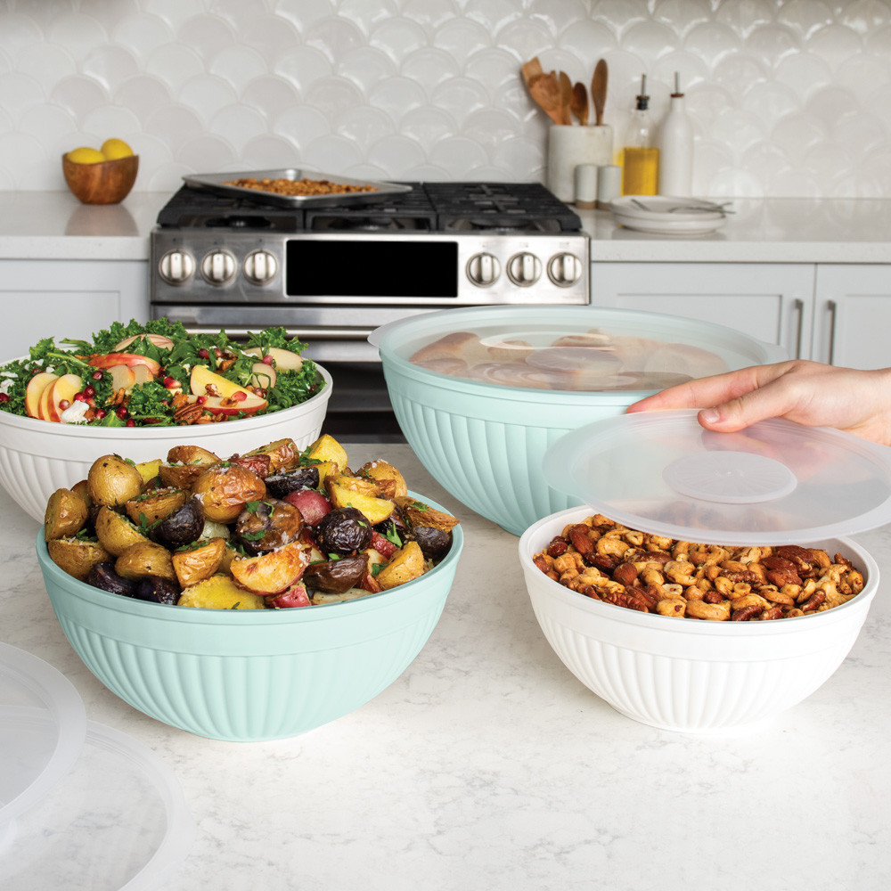 Nordic Ware 8 piece seaglass and white 7 quart, 5 quart, 3.5 quart and 2 quart bowls filled with salad, potatoes, mixed nuts and rolls