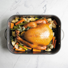 cooked turkey and veggies staged inside Nordic Ware Verde Grand Roaster with speckled nonstick interior and stainless steel handles