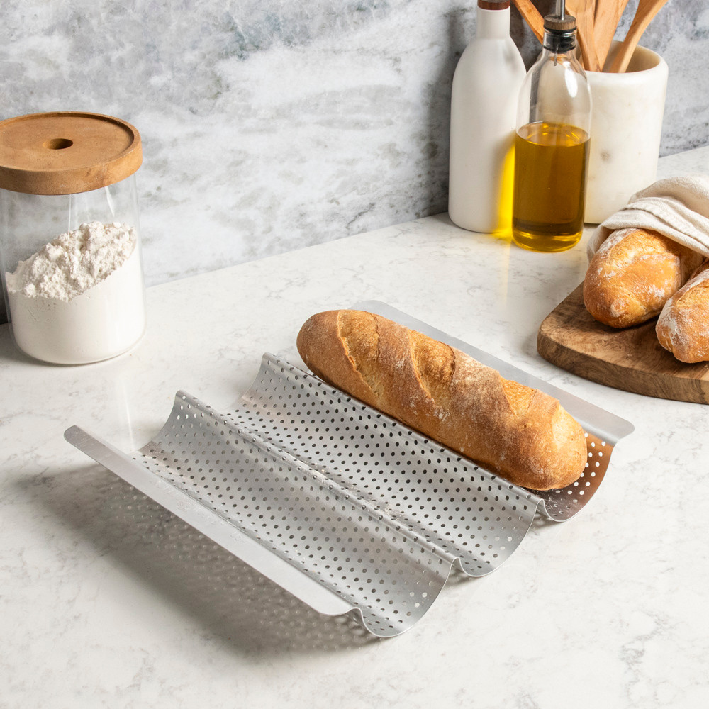 fresh baked baguette nested in a well of Nordic Ware baguette & french bread pan