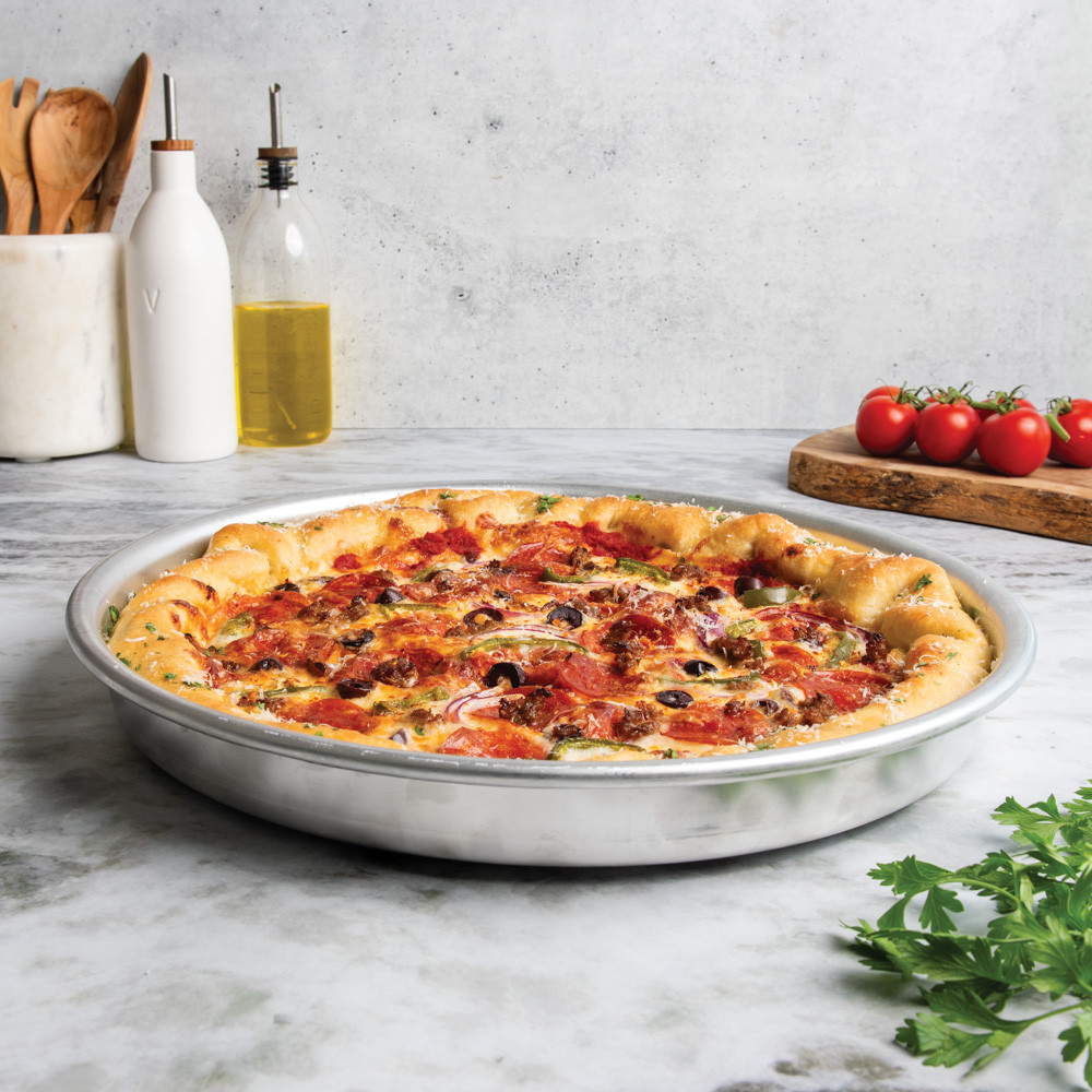 nordic ware 14 inch deep dish pizza pan with supreme pizza on countertop 