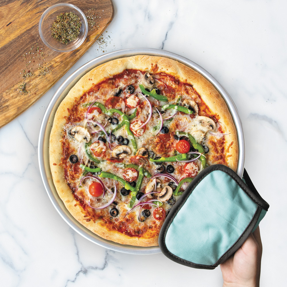 hand using hot pad to hold pizza pan with supreme pizza
