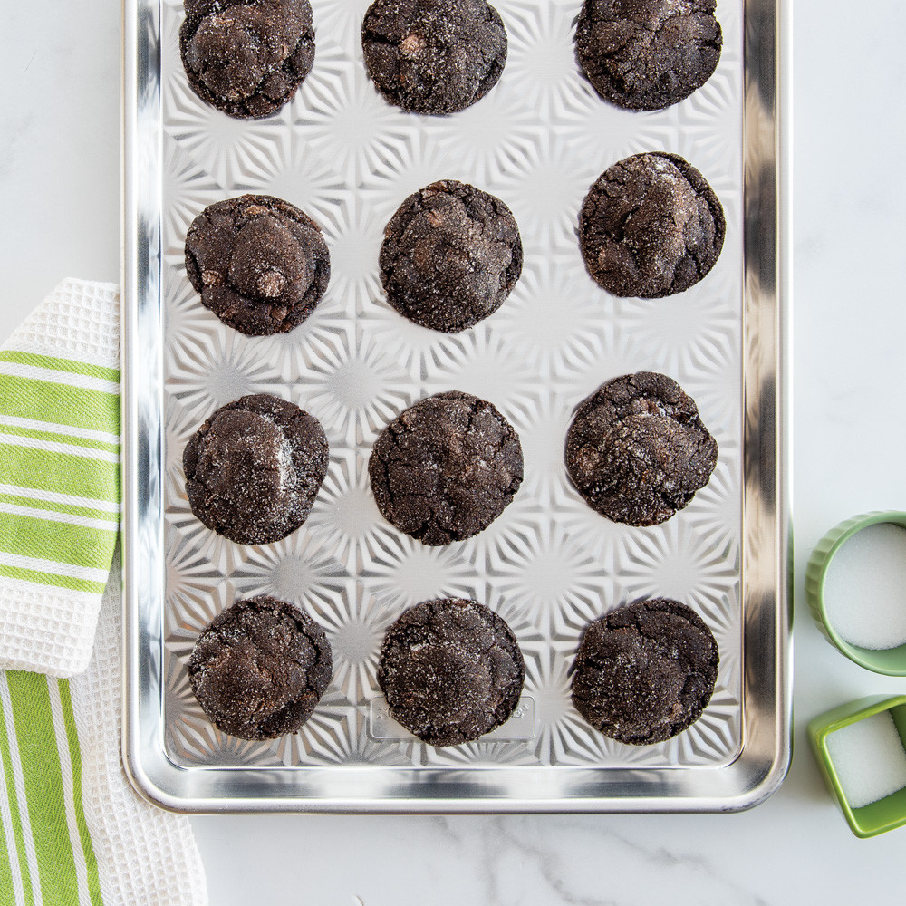 Chocolate cookies arranged on Nordic Ware Naturals aluminum half sheet pan with vintage starburst textured bottom