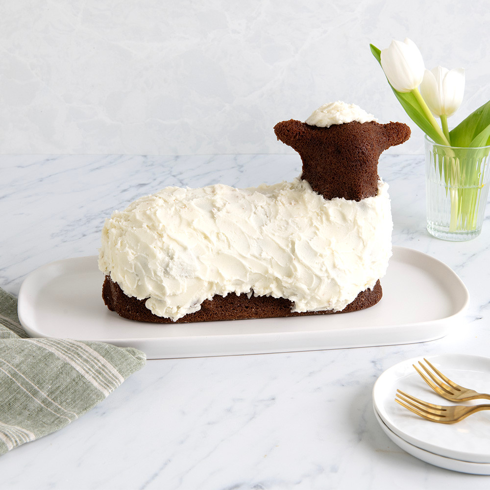 Chocolate lamb cake baked in Nordic Ware 3D lamb pan, decorated with white icing details on serving plate