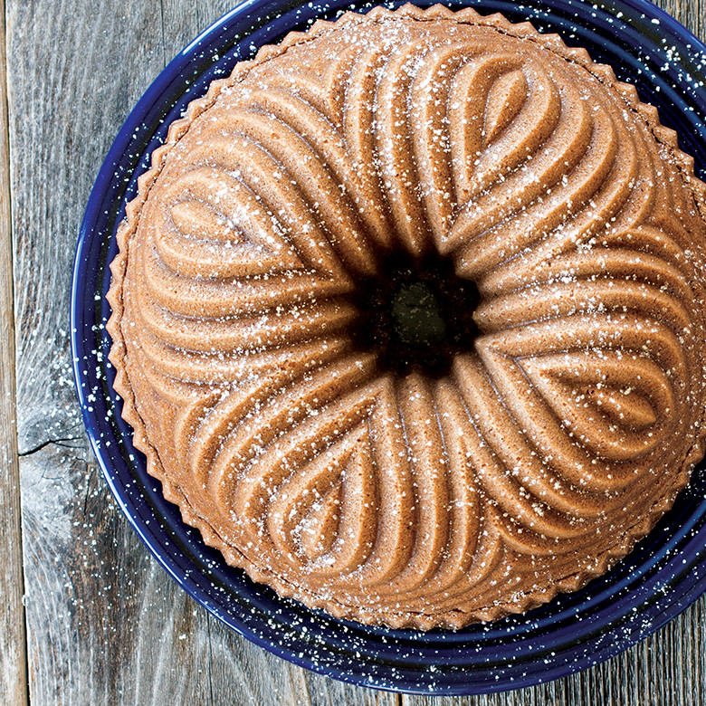 Golden bundt cake with powdered sugar dusting baked in Nordic Ware Bavaria bundt pan, showing ornate fluted pattern