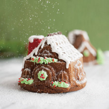 Two baked gingerbread houses from Nordic Ware aluminum duet pan, golden brown with detailed walls and roofs
