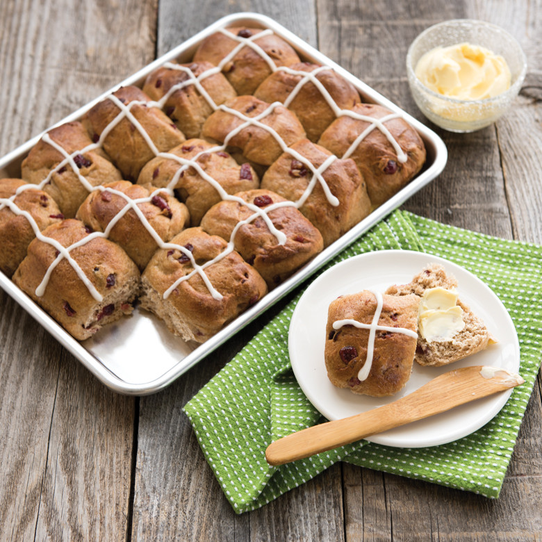 Golden hot cross buns with crosses piped on top, baked on Nordic Ware natural aluminum quarter sheet pan