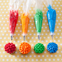 Nordic Ware pastry decorating set with four piping bags, colorful frosting tips, and four decorated cupcakes
