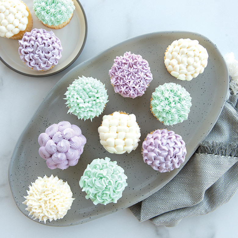 Frosted cupcakes displaying various piping techniques made with Nordic Ware 27-piece decorating tip set