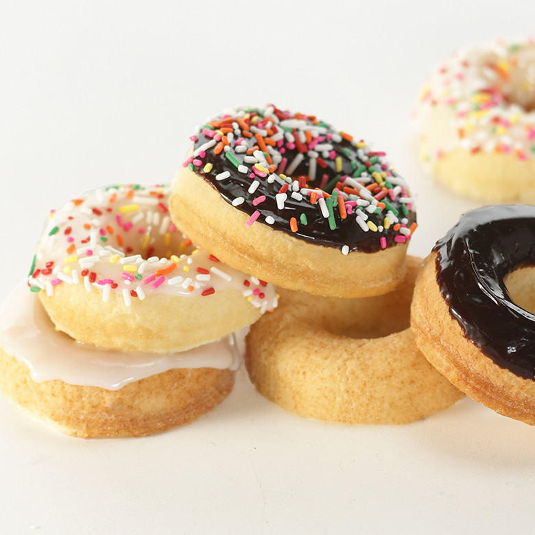 Nordic Ware aluminum donut pan with six glazed donuts, colorful frosting and sprinkles