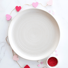 Valentine's Day charcuterie board with heart-shaped cookies, chocolate treats, and berries arranged on wooden surface
