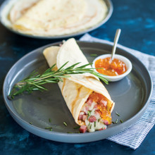 Savory crepe filled with ham and cheese on white plate, made using Nordic Ware French steel crepe pan