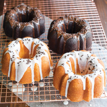 Two mini bundt cakes from Nordic Ware 3-cup bundt pan, one chocolate with white glaze, one vanilla with brown glaze