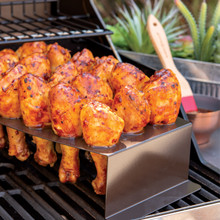 Nordic Ware aluminum chicken leg griller with four golden-brown grilled chicken drumsticks standing upright