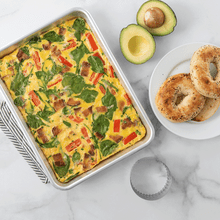 Baked egg casserole with vegetables in Nordic Ware aluminum quarter sheet pan, golden brown and bubbly