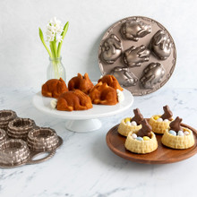 Nordic Ware aluminum pans with golden shortcake basket cakes, chocolate bunny decorations, and baby bunny cakelets