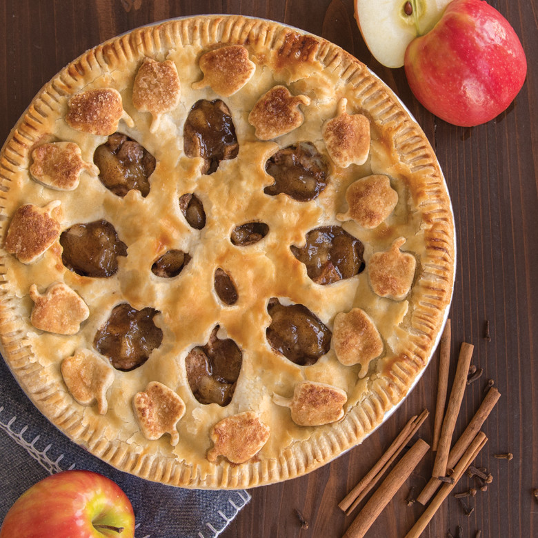 Golden-brown apple pie with decorative leaf and apple cutout crust design baked using Nordic Ware pie cutter