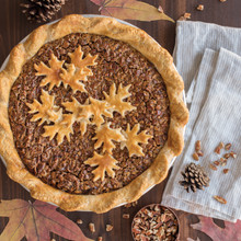Pecan pie with decorative leaf-shaped pastry cutouts on golden crust, made using Nordic Ware pie cutter