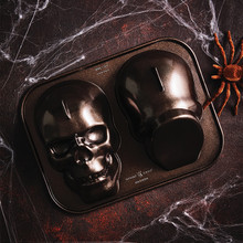 Nordic Ware aluminum haunted skull cake pan, dark gray finish, showing detailed bone structure and eye sockets