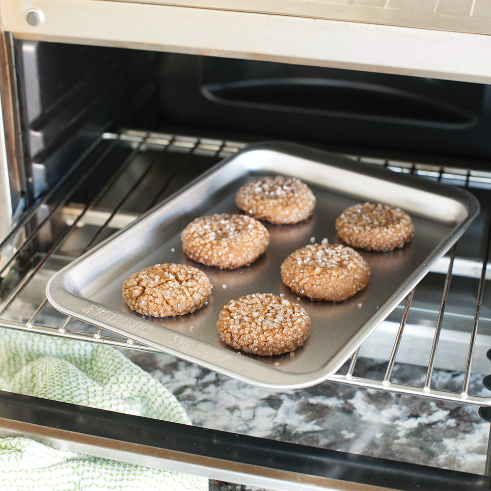 Nordic Ware aluminum compact baking sheet with golden brown gingerbread cookies arranged in rows