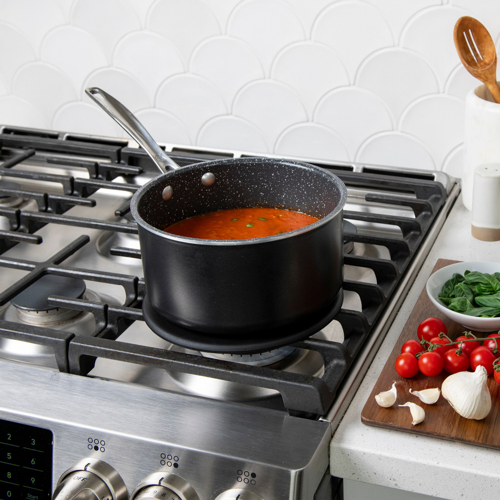 Lifestyle image of saucepan on heat tamer over a gas stove