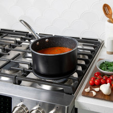 Lifestyle image of saucepan on heat tamer over a gas stove