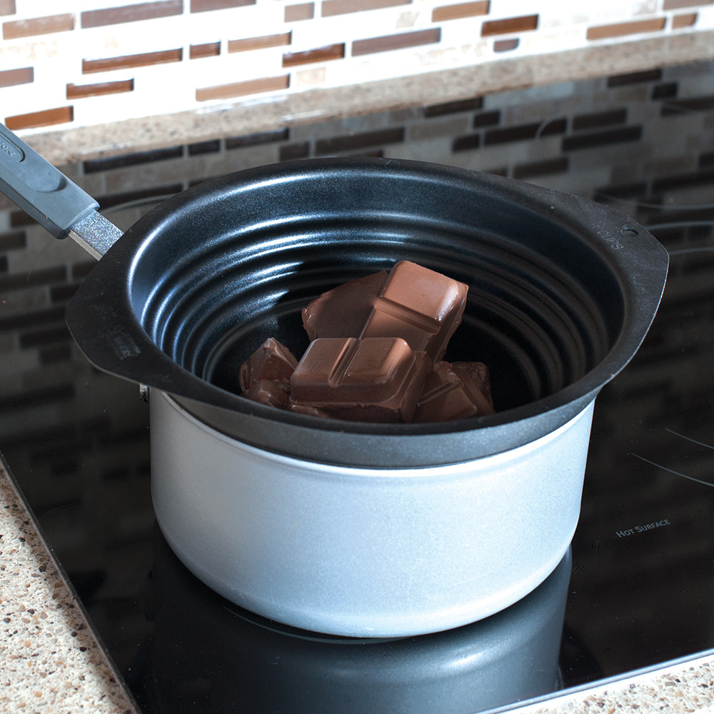 Nordic Ware nonstick double boiler insert in saucepan with melted dark chocolate, silver aluminum finish
